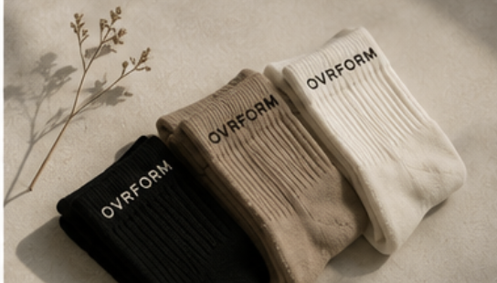 OVRFORM grip socks in cream, oat and black on a warm studio surface